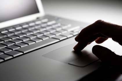 Hand tapping on the trackpad mouse of a computer keyboard